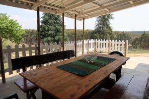 una mesa de madera con una copa de vino encima en Rocks & Roses Farm stay, en Lochiel