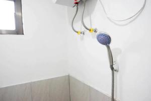 a shower head on a wall in a bathroom at RedDoorz Syariah near Universitas Jenderal Soedirman 2 in Purwokerto