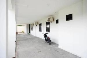 a scooter parked in a hallway of a white building at RedDoorz Syariah near Universitas Jenderal Soedirman 2 in Purwokerto