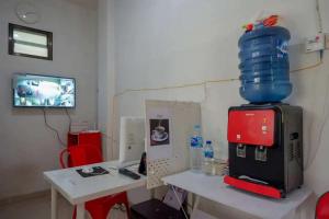 a room with a table with a water bottle on top at RedDoorz Syariah near Universitas Jenderal Soedirman 2 in Purwokerto