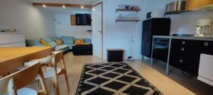 a kitchen and living room with a table and a couch at Rantasumppu 14, mökki viilennyksellä in Hailuoto