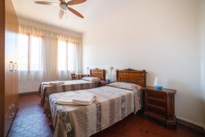 a bedroom with two beds and a ceiling fan at Ostello Domus Civica in Venice