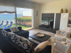 a living room with a couch and a television at Villa Farell just in front of the sea in San Pol de Mar