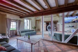 een woonkamer met een bank en een tafel bij Crazy Villa Les Terres Douces 28 - Heated pool - Basket - 2h Paris - 31p 