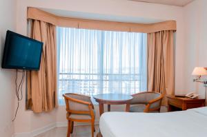 Habitación de hotel con cama, mesa y ventana en Millennium Apartments en Mendoza