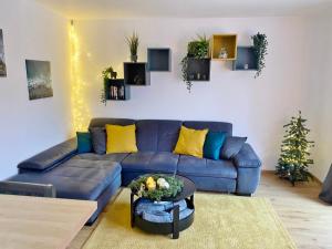 un salon avec un canapé bleu et un arbre de Noël dans l'établissement Appartement Aussen PFUI - Innen HUI, à Willingen