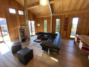 a living room with a black leather couch and chairs at Ferienhaus Sonnenchalet in Bodman-Ludwigshafen