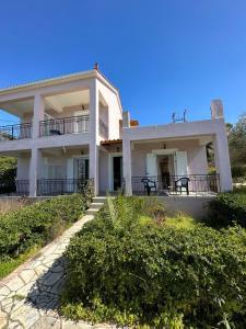 a large white house with a balcony at Alexandra’s Studios Sunset View in Argostoli