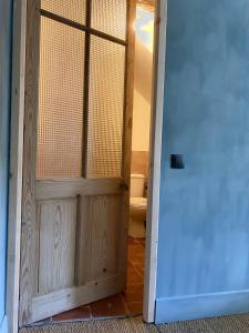 uma porta que leva a uma casa de banho com WC em Cévennes - Magnifique chambre d'hôtes, indépendante et moderne em Monoblet