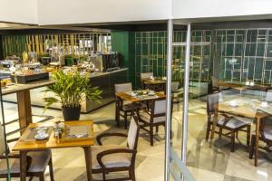 uma sala de jantar com mesas e cadeiras num restaurante em Urban Green Hotel & Suites em San José