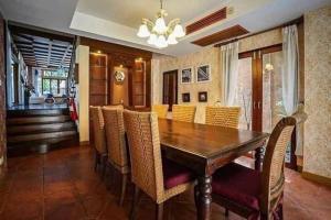 - une salle à manger avec une table et des chaises en bois dans l'établissement MamaLek Boutique Pattaya Poolvill 20m to Beach, à Na Jomtien