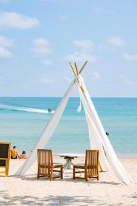 a tent on the beach with chairs and a table at Bay Beach Resort in Choeng Mon Beach