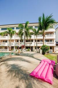 una tabla de surf rosa sentada frente a un edificio en Bay Beach Resort, en Choeng Mon Beach