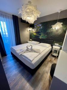 una camera da letto con un grande letto bianco e un lampadario a braccio di Gec a Zaprešić