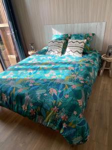 een bed met een blauw dekbed en kussens bij Coté Dune in Le Crotoy