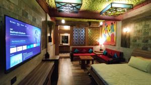 um quarto com uma televisão, uma cama e um sofá em Shivaaz Holiday Farms - Near Mopa Airport Goa em Dodamarg