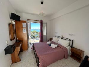 a bedroom with a bed with a pink bedspread at Alexandra’s Studios Sunset View in Argostoli
