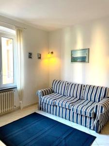 - un salon avec un canapé rayé et une fenêtre dans l'établissement Splendido trilocale a due passi dal mare, à Santa Margherita Ligure