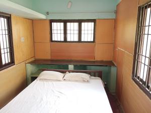 a large bed in a room with windows at vacation Home Stay in Pondicherry