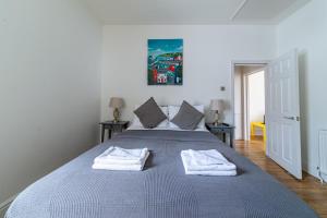 a bedroom with a bed with two towels on it at Woodgrange in Southend-on-Sea