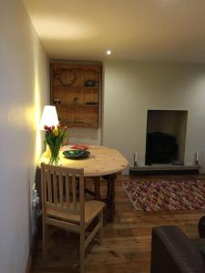 uma mesa de jantar com um vaso de flores em The Quirky, cosy hideaway! An apartment close to Leeds City Centre em Amley