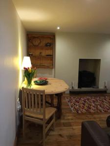 a dining room table with a vase of flowers on it at The Quirky, cosy hideaway! An apartment close to Leeds City Centre in Amley