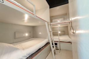 two bunk beds in a small room with a ladder at Jurockotel in Pattaya