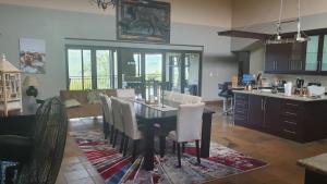 a dining room with a table with white chairs at 113 Zwartkloof Private Game Reserve Bela-Bela in Bela-Bela