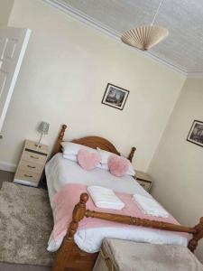 Homely Apartment near the Beach with Mini Luxuries في Methil: غرفة نوم مع سرير مع وسائد وردية وبيضاء