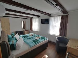 a bedroom with a large bed with two chairs at Hotel garni "Alter Fritz" in Quedlinburg