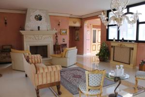 a living room with a fireplace and a chandelier at Villa la Bifora by Salento com in Castrignano del Capo