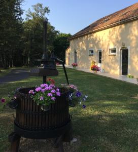 a bird bath with flowers next to a building at Camping les petites minaudières in Les Naux