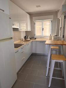 a kitchen with white cabinets and a table and chairs at CASA AZUL SANTA KATALINA in Mundaka