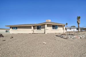 a large white house with a palm tree in front of it at Family Friendly Vacation Rental with Gas Grill! in Lake Havasu City