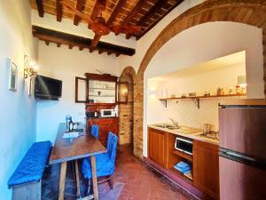 cocina con mesa de madera y nevera en Convento San Gimignano Apartments, en San Gimignano