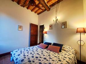 een slaapkamer met een bed met 2 kussens erop bij Convento San Gimignano Apartments in San Gimignano