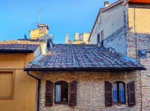 een oud bakstenen gebouw met ramen en een dak bij Convento San Gimignano Apartments in San Gimignano