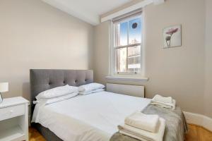 a bedroom with a large white bed and a window at Oxford Street Central Apartments in London