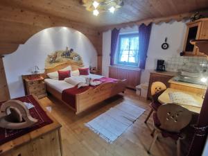 ein Schlafzimmer mit einem Bett und einem Tisch sowie eine Küche in der Unterkunft Schlosserhof in Telfes im Stubai