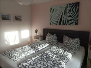 a bedroom with a bed and a zebra painting on the wall at Kleine Auszeit in Stakendorf