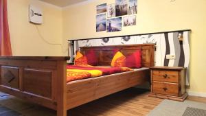 バンシンにあるFerienwohnung Kastanienblick mit Wlanの大きな木製ベッド(赤い枕付)が備わる客室です。