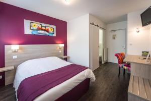 um quarto de hotel com uma cama e uma secretária em Logis hôtel restaurant la Haute Forêt em Vertou