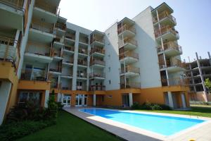 an apartment building with a swimming pool in front of it at Viktória Beach Apartman Gold 1. Siófok in Siófok