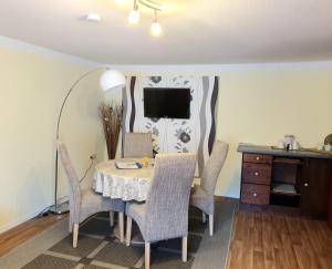 ein Esszimmer mit einem Tisch, Stühlen und einem TV in der Unterkunft Ferienwohnung Kastanienblick mit Wlan in Bansin