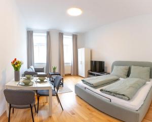 a bedroom with a bed and a table and a dining room at City Apartments Vienna in Vienna