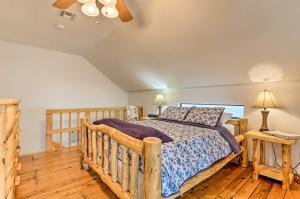 una camera con letto e pavimento in legno di Medicine Park Cabin Rental with Mountain View a Medicine Park