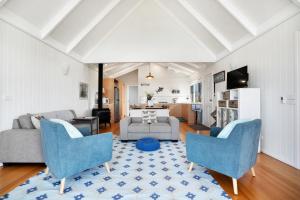 a living room with blue chairs and a couch at Bear Gully Coastal Cottages in Walkerville