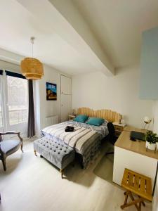 a bedroom with a bed and a desk and a chair at Le Saint-Rémy, hyper centre, calme in Dieppe