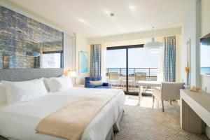 シッチェスにあるEurostars Sitgesのベッド付きのホテルルームで、海の景色を望めます。
