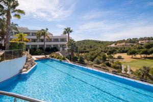 uma piscina num resort com um campo de golfe em Eurostars Sitges em Sitges
